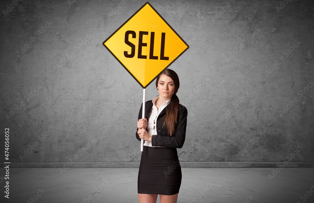 Young business person holding road sign Young business person holding road sign