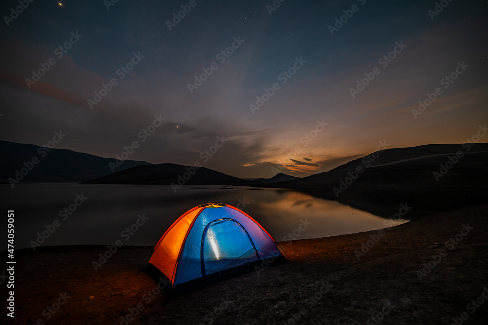Tent in the  lakeshore in the beautiful mountains. Night camping.