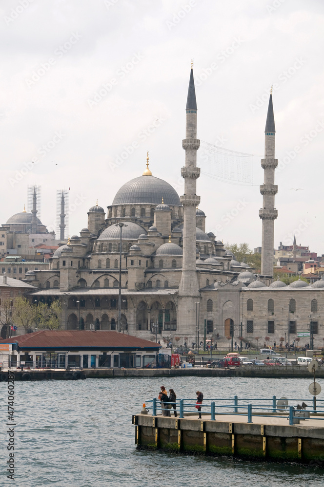 Naklejka premium Embarcadero en el Bósforo y vista de la mezquita de Yemi Cami en la ciudad de Estambul en Turquía