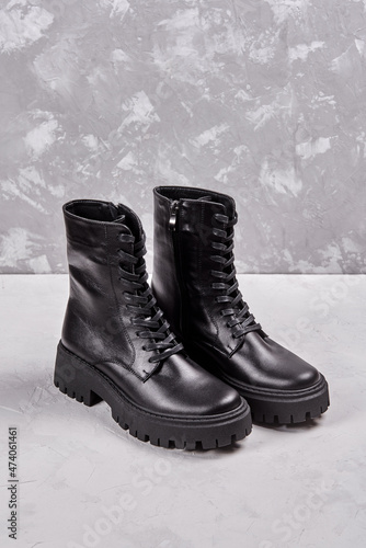 Black leather female boots isolated on gray background, copy space