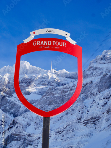Fotografia Mountain station of Saentis cable car seen through Grand Tour of Switzerland sign in winter