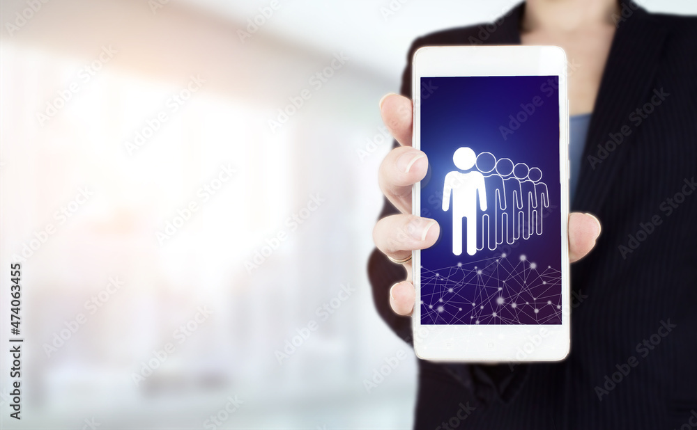 Business communication concept. Marketing. Teamwork. Hand hold white smartphone with digital hologram Human, Leader sign on light blurred background. Human search.Leader and CEO.