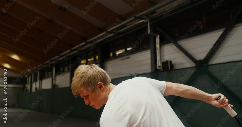 A man starts a tennis set, hitting the ball on the floor before throwing A man starts a tennis set, hitting the ball on the floor before throwing