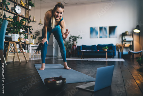 Girl using laptop on fitness mat at home