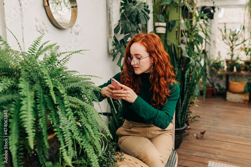 Positive red haired female using a smartphone photo
