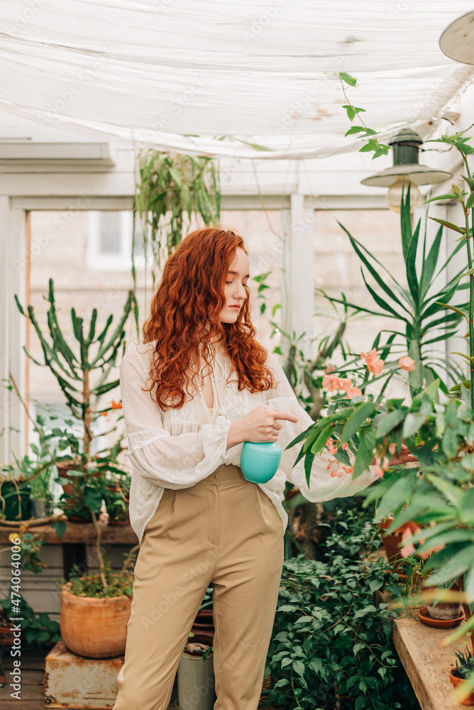 Woman spraying potted plants with water Woman spraying potted plants with water