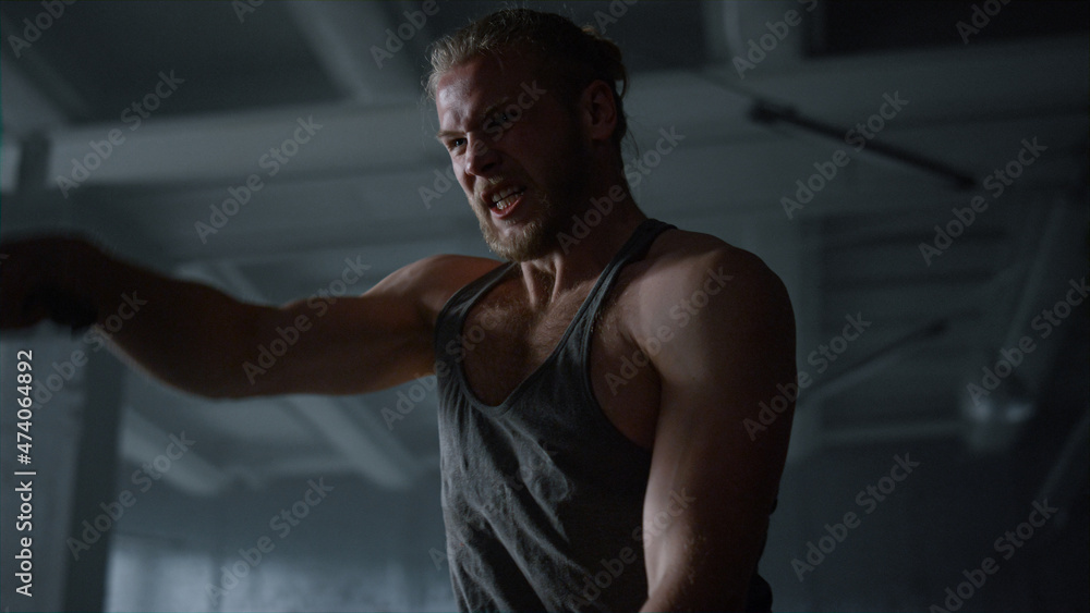 Strong sportsman battling ropes in gym. Sporty man using sports equipment Strong sportsman battling ropes in gym. Sporty man using sports equipment