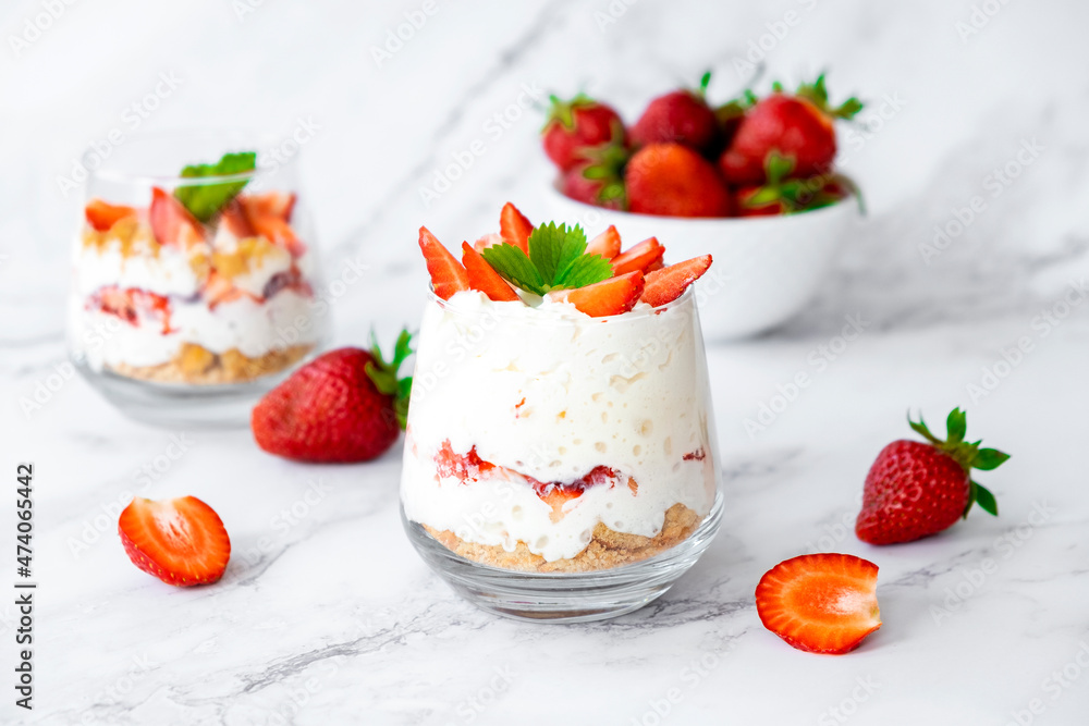 Strawberry dessert with cream cheese or yogurt, granola and fresh strawberry in glass. Festive layered dessert in glass. Vegan lactose free dessert with alternative nut milk. Strawberry dessert with cream cheese or yogurt, granola and fresh strawberry in glass. Festive layered dessert in glass. Vegan lactose free dessert with alternative nut milk.