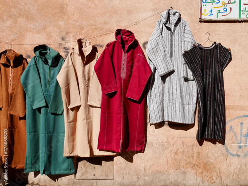 Marrakech, Morocco, 25.01.2020. Colorful hand tailored Moroccan caftans displayed for sale on a wall in the Medina. photo