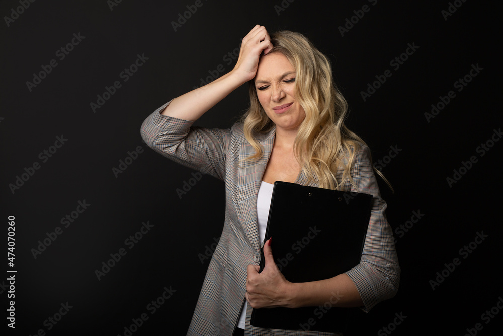 portrait of adult caucasian woman holding a folder of documents on a black background portrait of adult caucasian woman holding a folder of documents on a black background