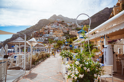 Fototapeta Naklejka Na Ścianę i Meble -  Panorama of Positano city in Italy. Warm summer weather, sunny day. Coastline with restaurants and beach.