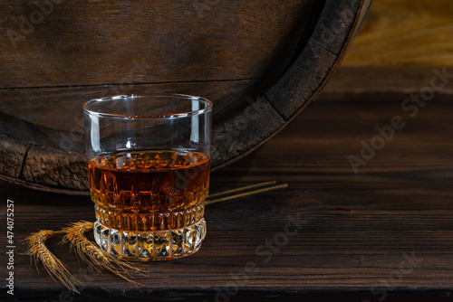 Canvas Print Glass decanter with whiskey, brandy on a vintage background of a rustic oaken barrel
