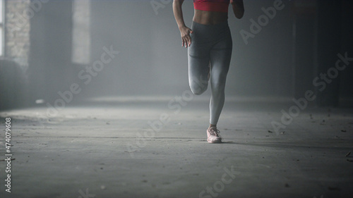 Athlete legs running fast in gym. Woman doing cardio workout in loft building