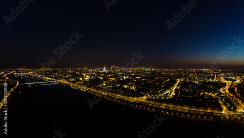 Warszawa nocą rozświetlona przez uliczne latarnie, nocny krajobraz z lotu ptaka #474082848