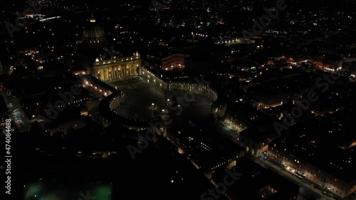 Aerial drone night video of illuminated Saint Peter's square, world's largest church - Basilica of St. Peter's, Vatican - an elliptical esplanade created in the mid seventeenth century, Rome, Italy photo