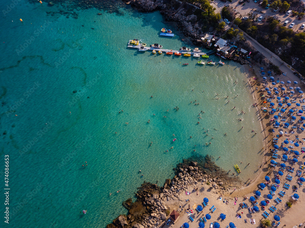 Aerial view on beautiful beach with sun loungers near azure sea