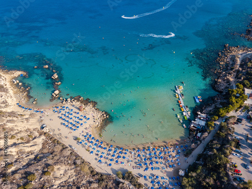 Aerial view on beautiful beach with sun loungers near azure sea