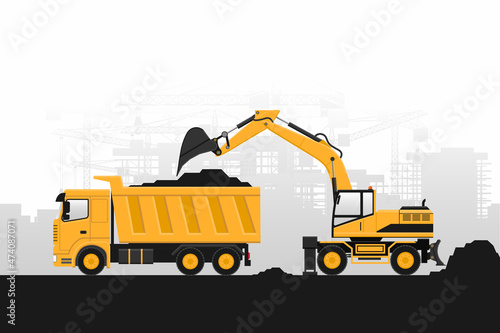 Background of heavy machinery of wheeled excavator filling with construction materials a truck on gray background