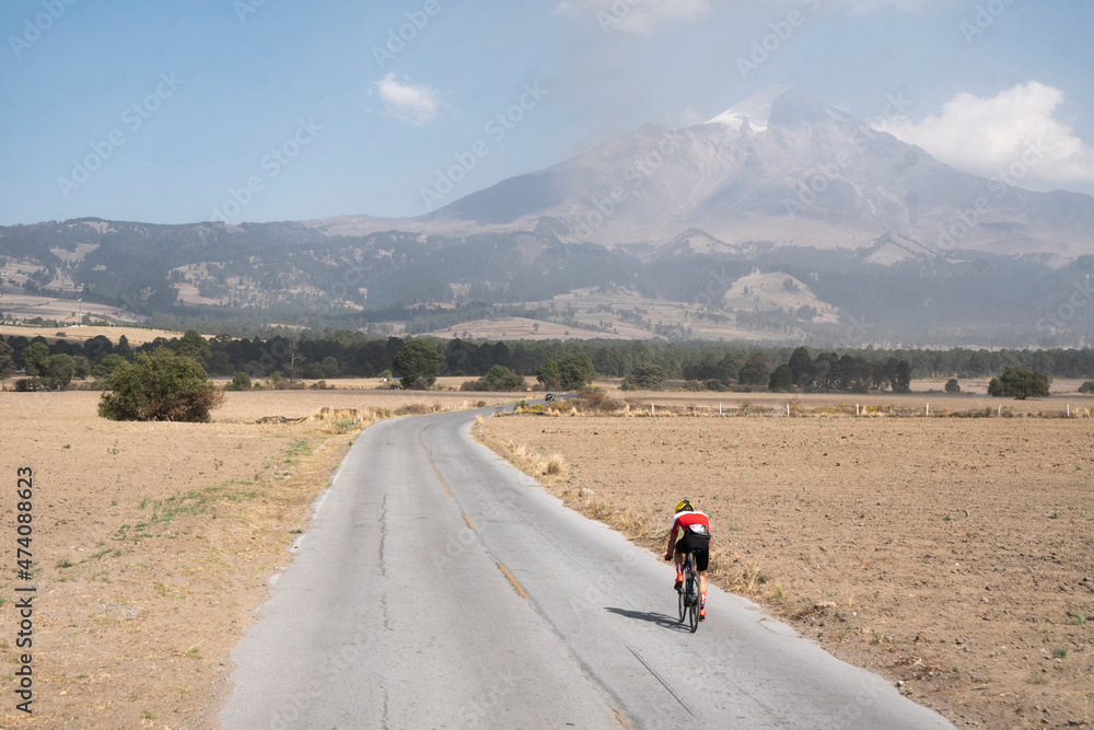 One man riding his bike on a lonely road towards Pico de Orizaba