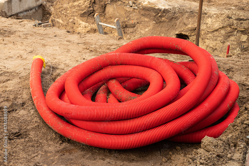 Red corrugated flexible plastic conduit for underground cable