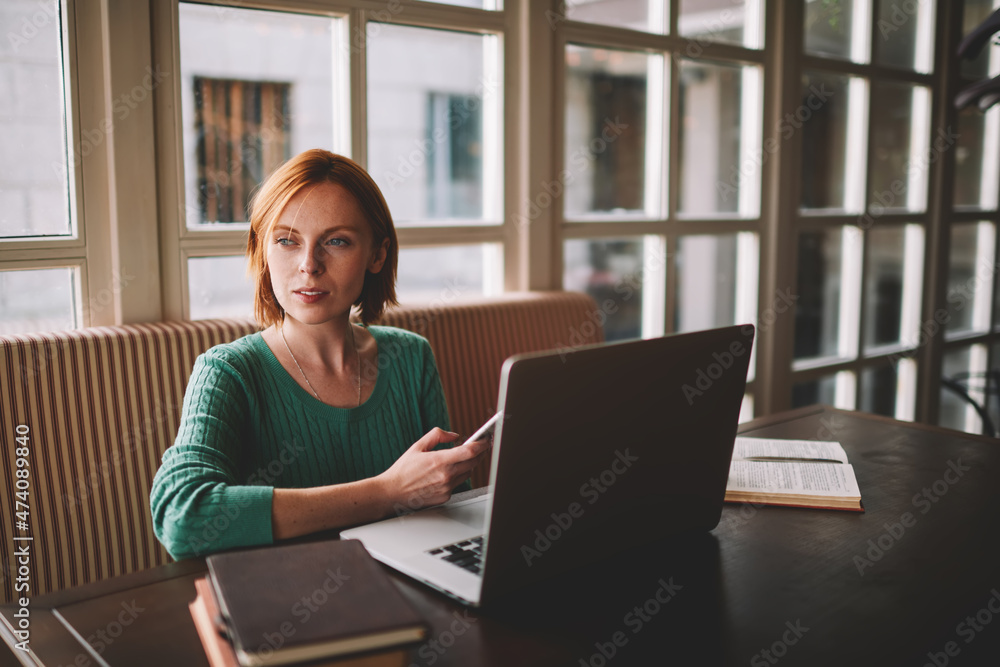 Pensive woman using smartphone while working Pensive woman using smartphone while working
