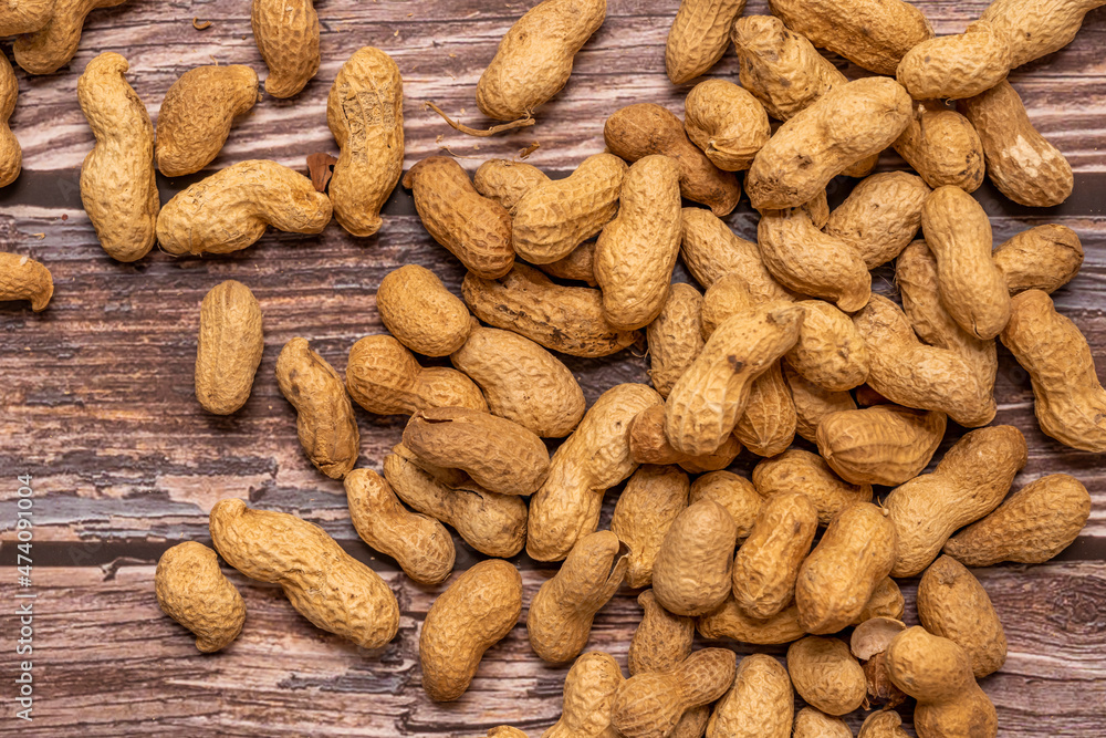 Top view image of peanuts in bulk on wooden table Top view image of peanuts in bulk on wooden table