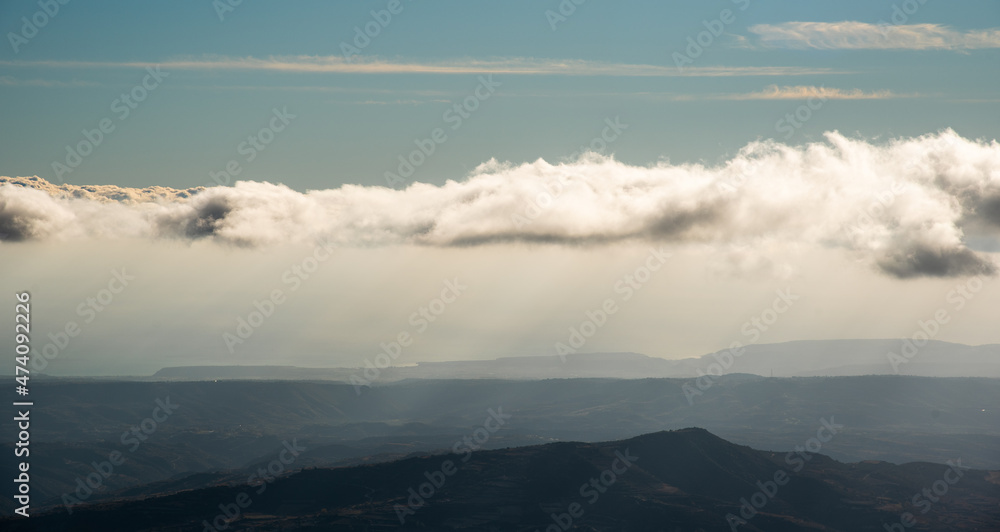 Cloudy sky with cumulus clouds above mountain cliffs. Moody atmosphere