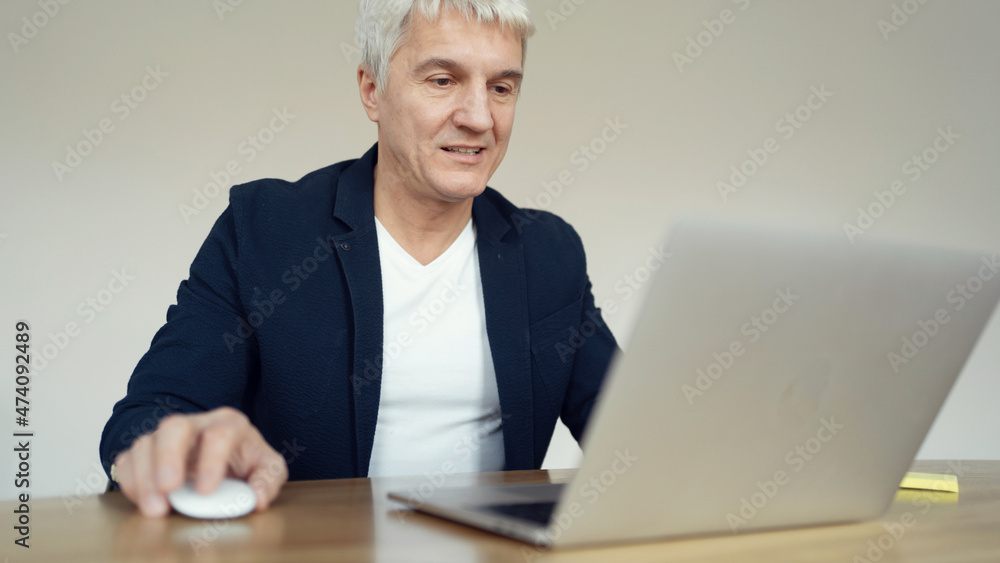 Works smiling on the internet on an online site. Financier stylish age gray workplace in the office. Works smiling on the internet on an online site. Financier stylish age gray workplace in the office.