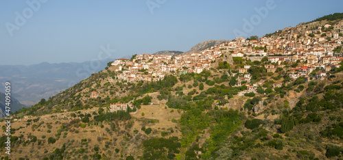 Panoram of the small town with Red Brick Roof houses on the hill with mountains on the background