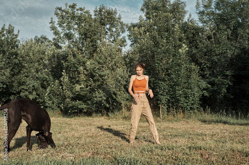 woman playing with a big black dog outdoors in the field fun friendship © VICHIZH