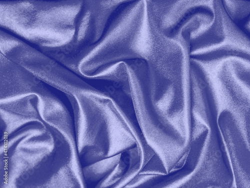 The color of 2022, Very Peri. Texture of Silk purple drapery. Beautiful wavy soft folds on surface of the satin fabric