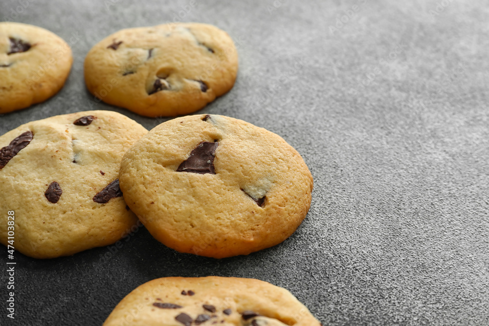 Tasty homemade cookies with chocolate chips on grey background, closeup