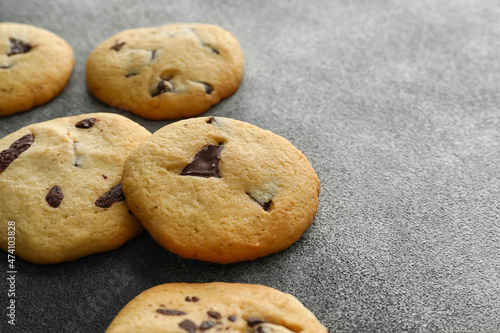 Tasty homemade cookies with chocolate chips on grey background, closeup © Pixel-Shot