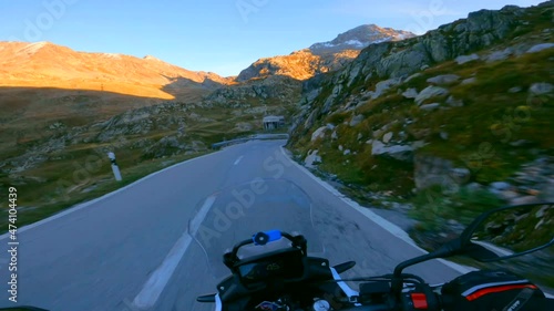 Riding a motorcycle on a scenic mountain road in the morning at sunrise, to the Sanetsch pass in Switzerland photo