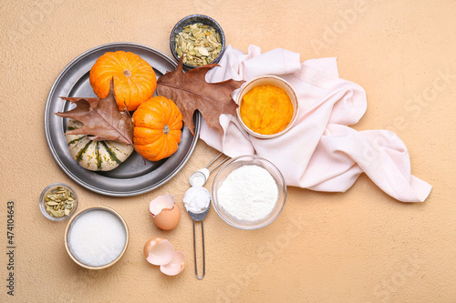 Fresh ingredients for preparing pumpkin pie on beige background