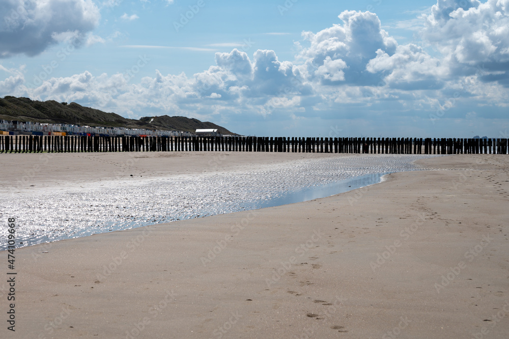 View on wooden poles at white sandy beach North sea near Zoutelande, Zeeland, Netherlands