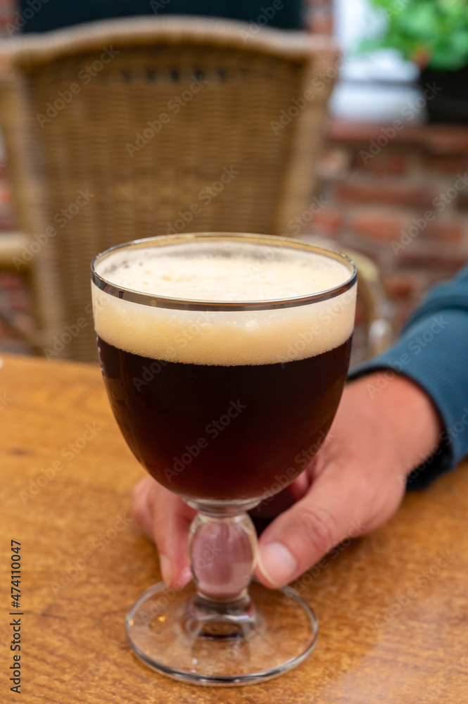 Glass of dark tasty Belgian dubbel brown beer from abbey brewery
