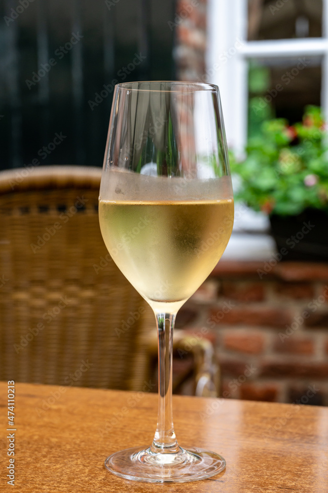 Glass of cold white wine served on outdoor terrace in old French cafe Glass of cold white wine served on outdoor terrace in old French cafe