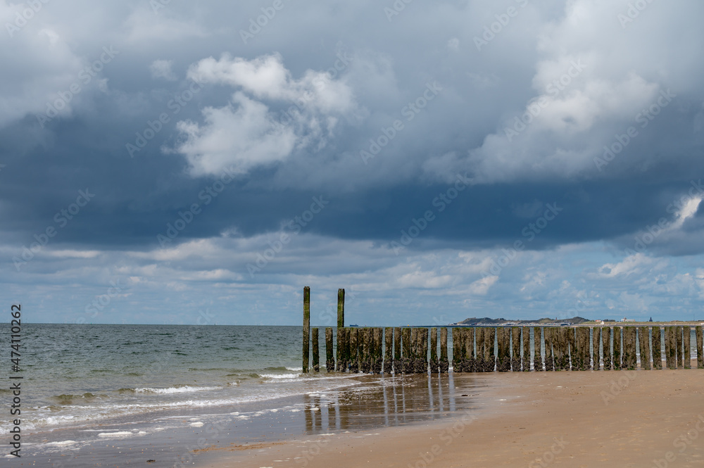Walking on white sandy North sea beach near Zoutelande, Zeeland, Netherlands before thunderstorm