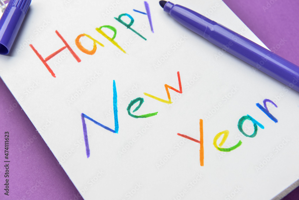 Notebook with text HAPPY NEW YEAR and marker on color background, closeup. LGBT concept Notebook with text HAPPY NEW YEAR and marker on color background, closeup. LGBT concept