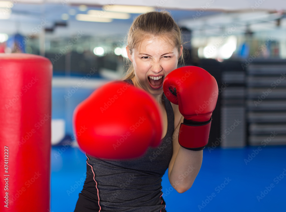 Portrait of young russian woman who is training in box gym.