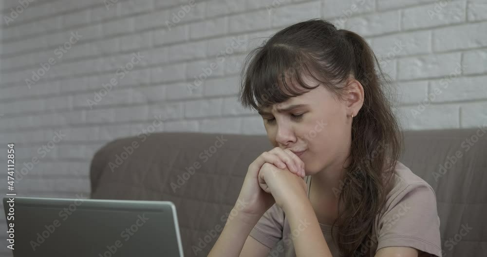 Suffering from online pressure. A stressed sad teenage girl suffering from online pressure on remote. Suffering from online pressure. A stressed sad teenage girl suffering from online pressure on remote.