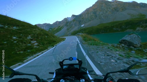 Riding a motorcycle on a scenic mountain road in the morning at sunrise, to the Sanetsch pass in Switzerland photo