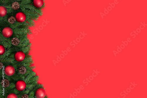 Christmas red background with fir branches and red baubles. Happy new year. Space for text. Copy space  template. Top view  flat lay.