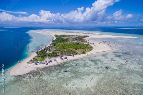 Aerial view of Maiga island panorama, beautiful blue lagoon and coral reef.