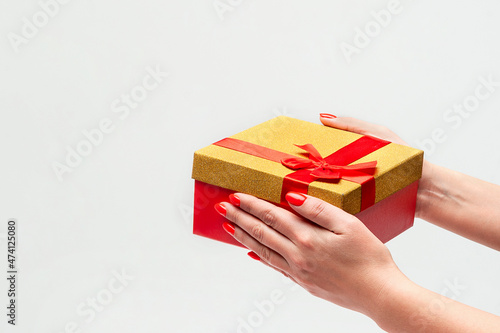 Gift box in female hands on a white background
