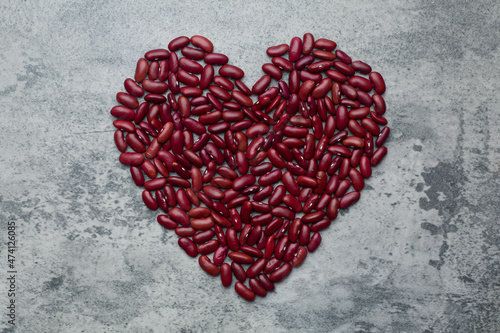 a pile grains red kidney beans heart shape on concrete background