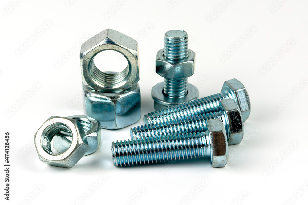 Large metal nuts with silver metal bolts. Close-up on a white background. A group of several nuts and bolts Large metal nuts with silver metal bolts. Close-up on a white background. A group of several nuts and bolts