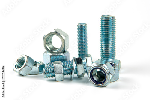 Large metal nuts with silver metal bolts. Close-up on a white background. A group of several nuts and bolts