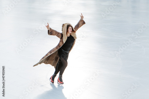 figure skater on ice. the girl is skating. ice under the open sky. No makeup in winter, red cheeks